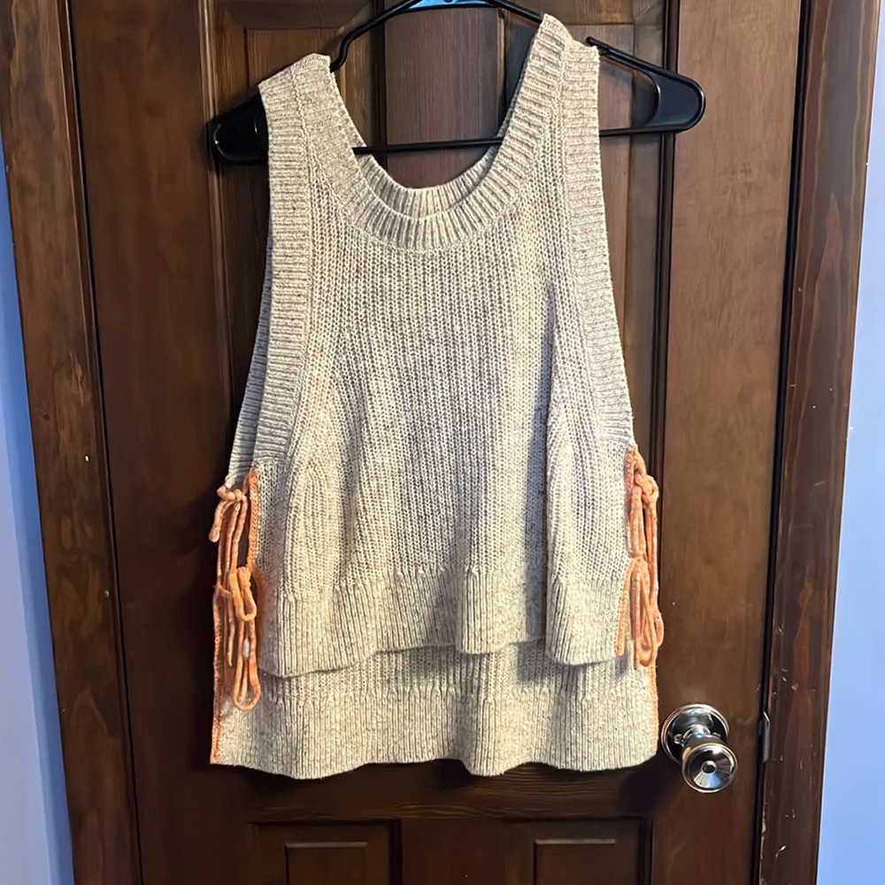 High to low knit off white tank with orange ties on the side